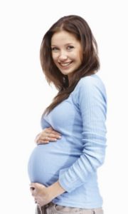 Portrait of a happy young pregnant woman holding her tummy , white background